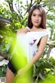 A woman in a white shirt and black shorts posing for a picture.